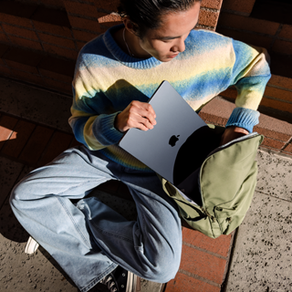 Vooraanzicht van iemand die een gesloten 15-inch MacBook Air in een tas stopt